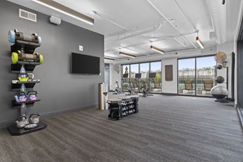 Room with gym equipment and a television at the district flats apartments